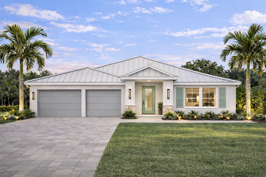 Aria Collection custom home at dusk with a white metal roof and three-car garage