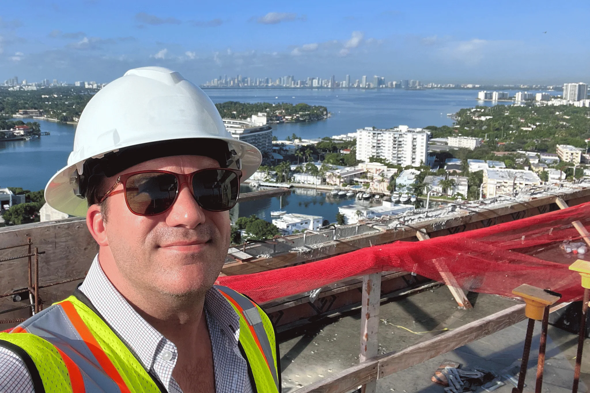 James J. Cloud on a Miami high-rise job site, with Biscayne Bay and the skyline behind