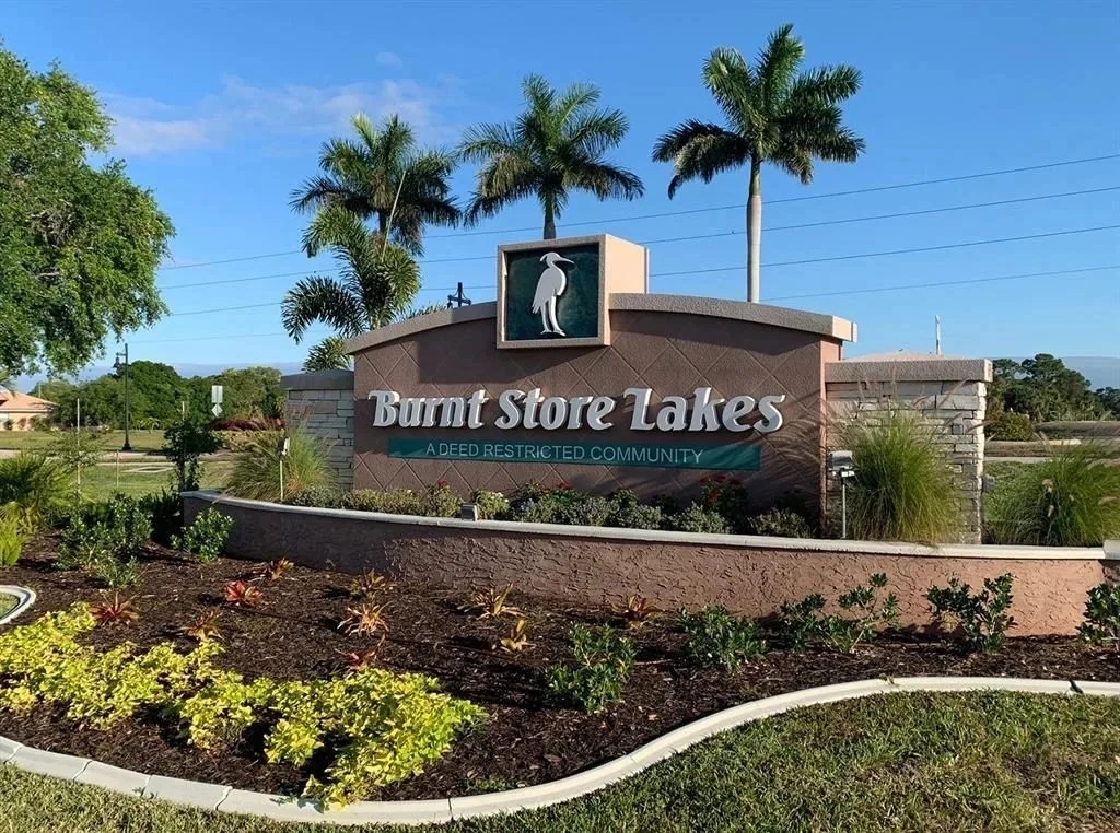 Burnt Store Lakes community entrance sign with royal palm trees